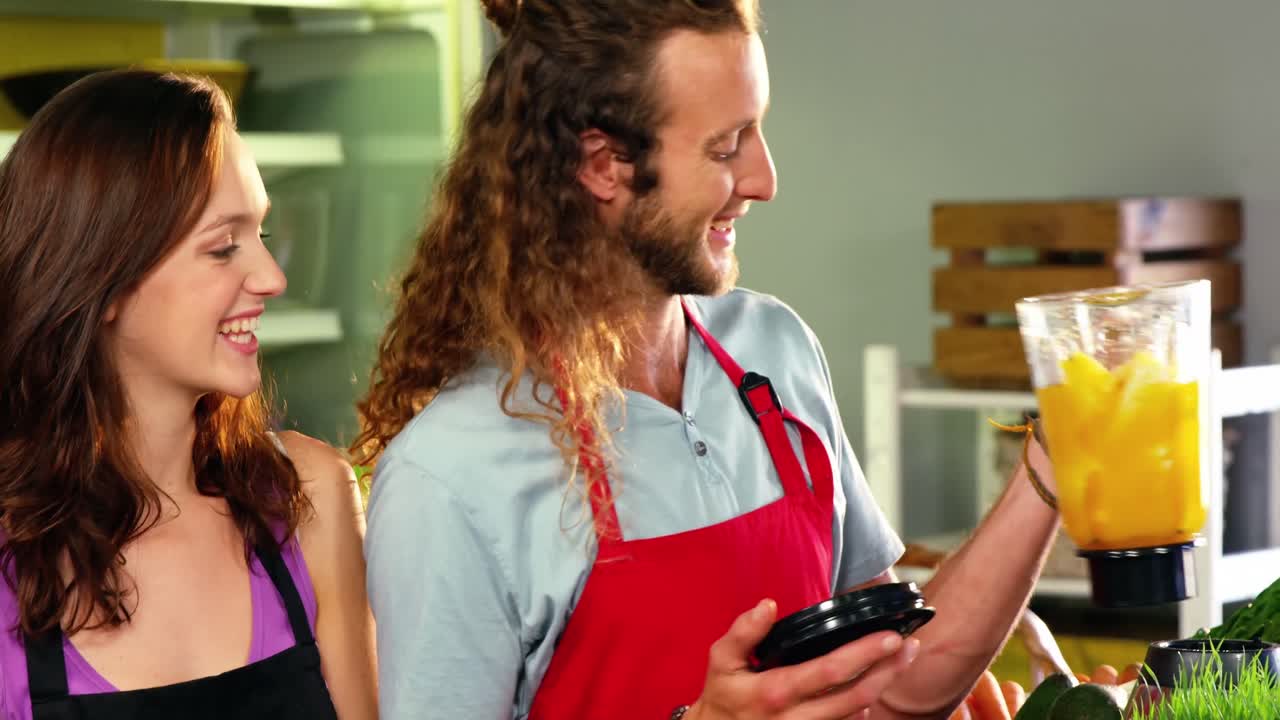 trabajadores que preparan jugo en mezclador