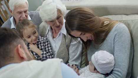 big family cooing over cute baby