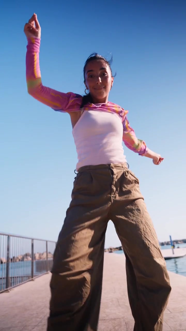 Young Woman Dancing Outdoors on a Sunny Day