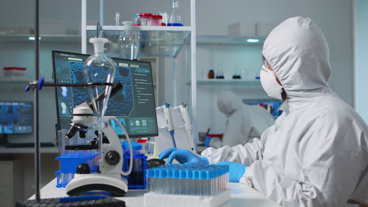 químico con abrigos analizando una muestra de bacterias de una placa de petri