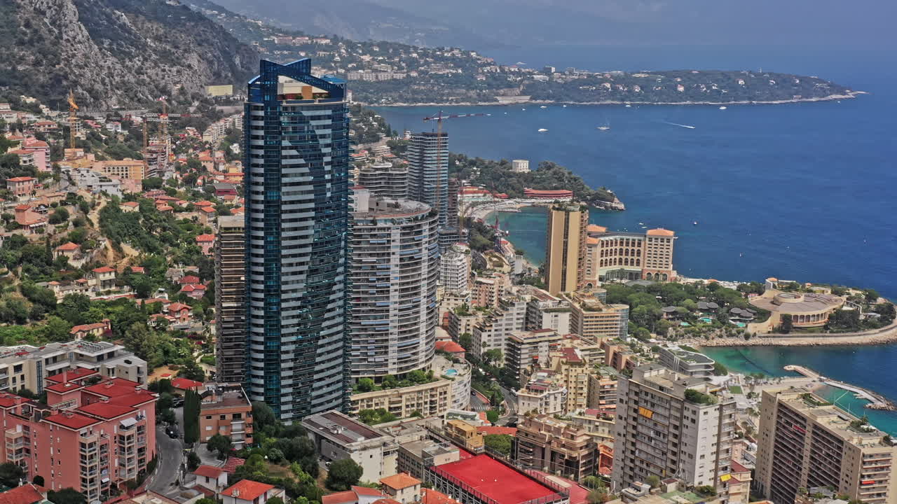 Mônaco Aérea v21 vista panorâmica sobre o bairro de Saint Roman, capturando a famosa Torre Odeon e propriedades residenciais e resorts circundantes - Julho de 2021.