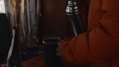 man pouring hot water into cup at a teahouse in nepal.