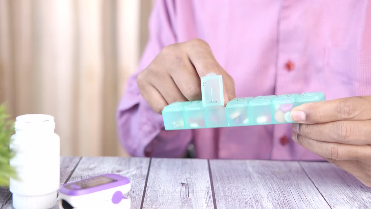 매일 약을 복용하는 사람, 알약 조직기 및 혈압 모니터.