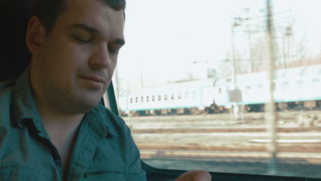 man taking a headache pill in the train