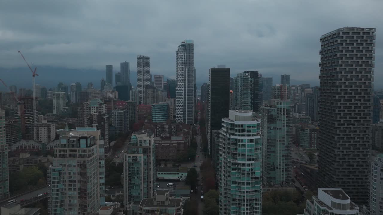Wide rising aerial shot of the downtown skyline on a rainy afternoon in Vancouver, British Columbia, Canada. 4K