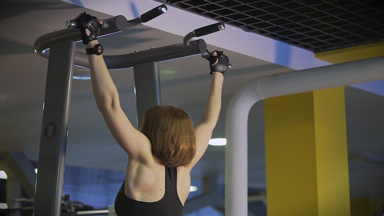 Woman Doing Pull-ups in Gym