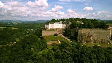 Drohne-Filmt-Eine-Historische-Burg-Auf-Dem-Hügel-In-Höhe-Des-Hügels,-Während-Sie-An-Einem-Bewölkten-Tag-In-Ostdeutschland-In-Entfernung-Um-Den-Berg-Kreist