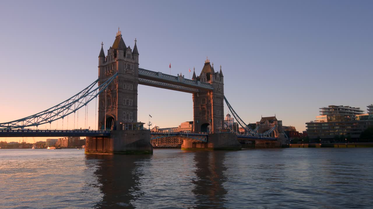 Victorian towers and suspension spans of Tower Bridge frame calm Thames at twilight, soft colors and water reflections evoke London’s classic charm in serene wide hyperlapse