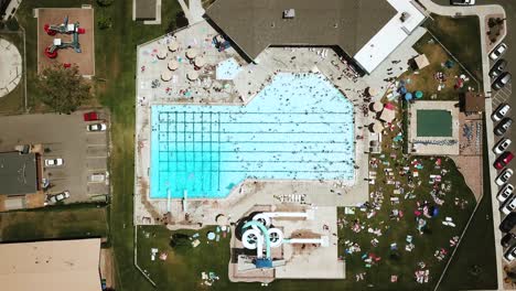 lowering drone shot directly above an outdoor public pool