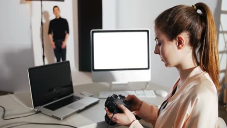 female photographer reviewing captured photos in his digital camera at studio