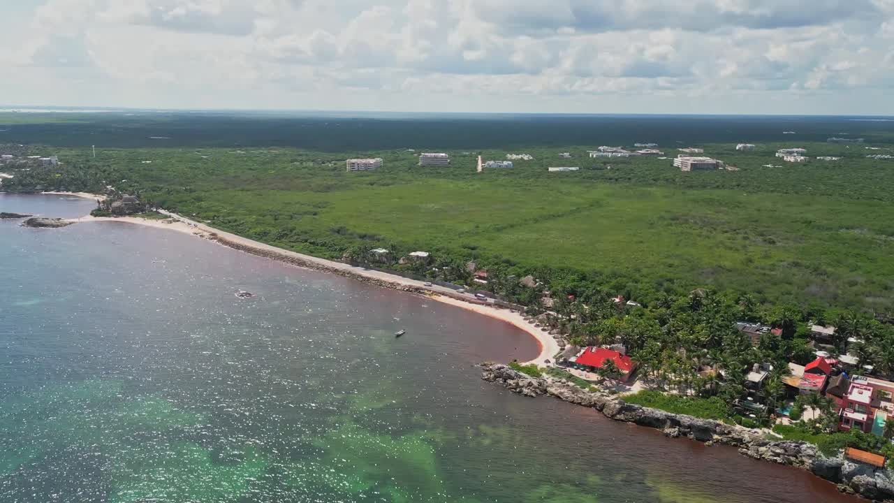Aerial view of Tulum beach with green waters under a cloudy sky