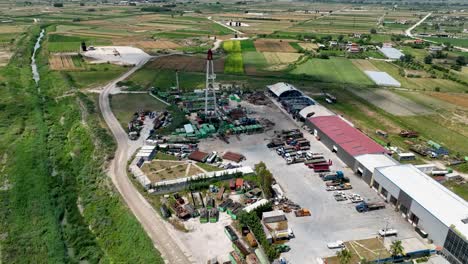 oil well inside industrial factory with farm land near by