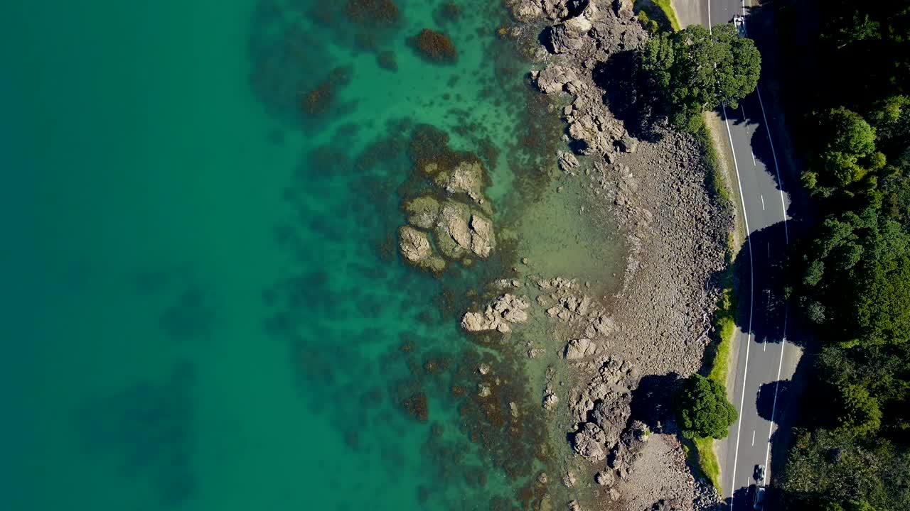 автомобили едут по самому живописному прибрежному участку дороги в новой зеландии