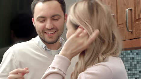 happy couple dancing listening to music in the kitchen at home