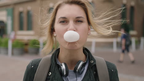 portrait of independent blonde woman blowing bubblegum smiling happy cheerful feeling relaxed carefree