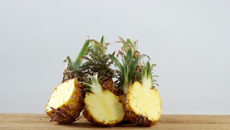 Halved-pineapples-on-wooden-table