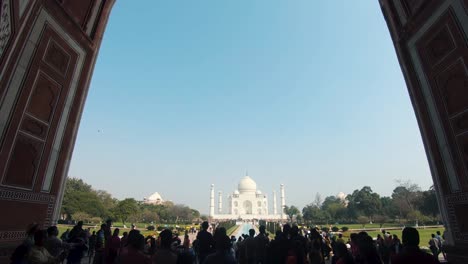 push in view from the main gateway (darwaza) to the taj mahal, crowded by tourists - wide dolly push in shot