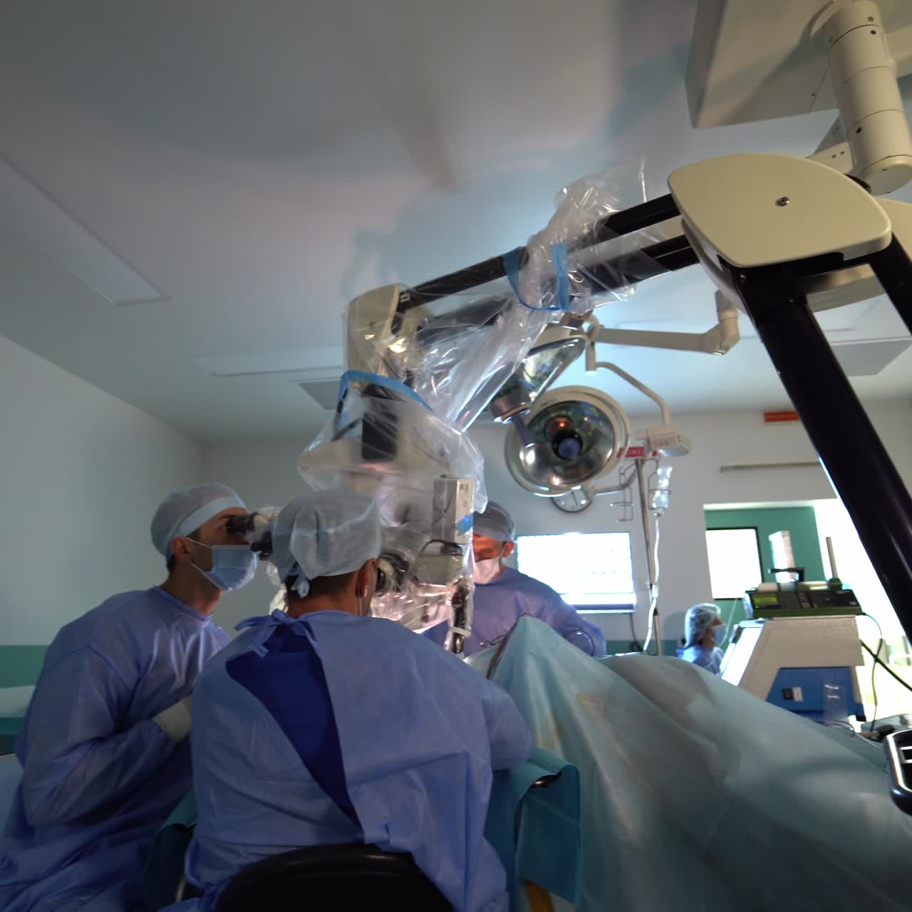 Complicated equipment for carrying out the neurosurgical operations. Look at the fastening of the volumetric equipment to the ceiling. Doctors leading the surgical operation
