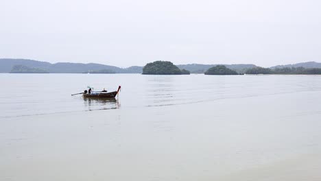 a boat glides across calm krabi waters