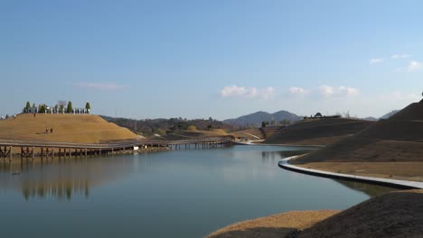 suncheonman bay lake garden in autumn, visitors walking on bonghwa hill spiral walkway trails and bridge of dreams, suncheon city, jeonnam, south korea