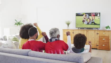 video of african american family sitting on the couch and watching football match