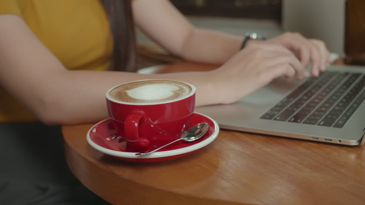 Woman Using Laptop With A Cup Of Coffee