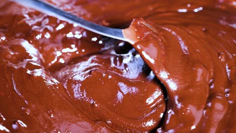 close-up of spoon stirring chocolate mixture