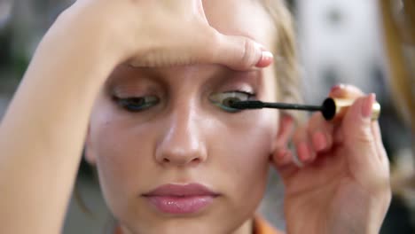 Make-up-artist-applying-eyelash-makeup-to-model's-eye.-Mascara-.Close-up-view