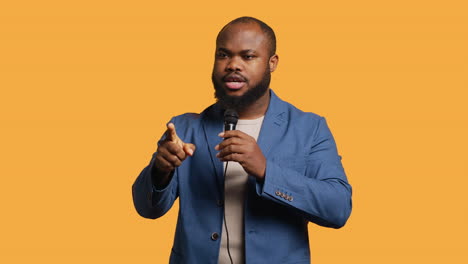 motivational speaker holding monologue using microphone, studio background