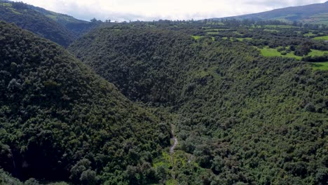 clip de drone cinematográfico sobre un cañón cubierto de plantas y un río en puichig, ecuador