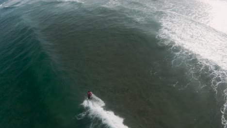 Aerial-perspective-of-bodyboarder-performing-360-spin-on-open-wave-face