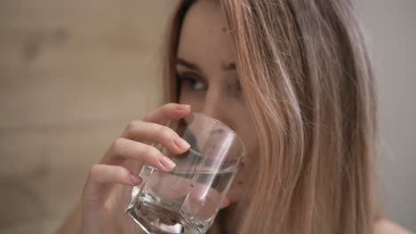 Attraktive-Frau,-Die-Nahrungsergänzungsmittel-Einnimmt-Und-Ein-Glas-Wasser-Trinkt