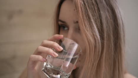 mujer atractiva tomando suplementos píldoras y beber un vaso de agua
