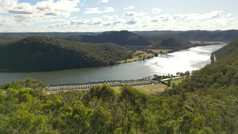 Eine-Schnelle-Kranbewegung-Einer-Drohne-Am-Hawkins-Lookout-In-Der-Nähe-Der-Wisemans-Ferry-In-Australien-Zeigt-Im-Hintergrund-Eine-Malerische-Aussicht-Auf-Den-Hawkesbury-River-Mit-Hügeln,-Die-Sich-Nach-Westen-Erstrecken