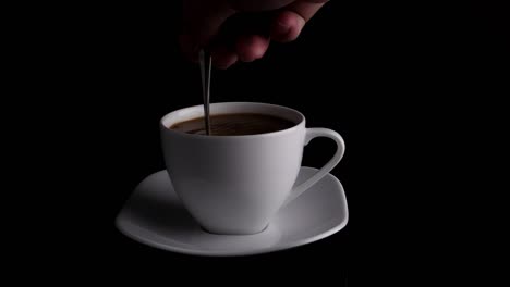 hand stirring coffee with spoon