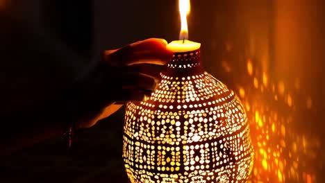 hand holding a candle in a decorative lantern