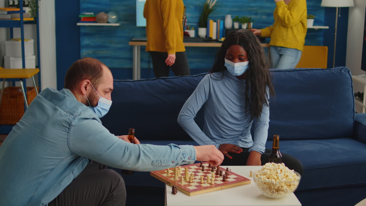 Une femme africaine portant un masque jouant aux échecs avec un homme