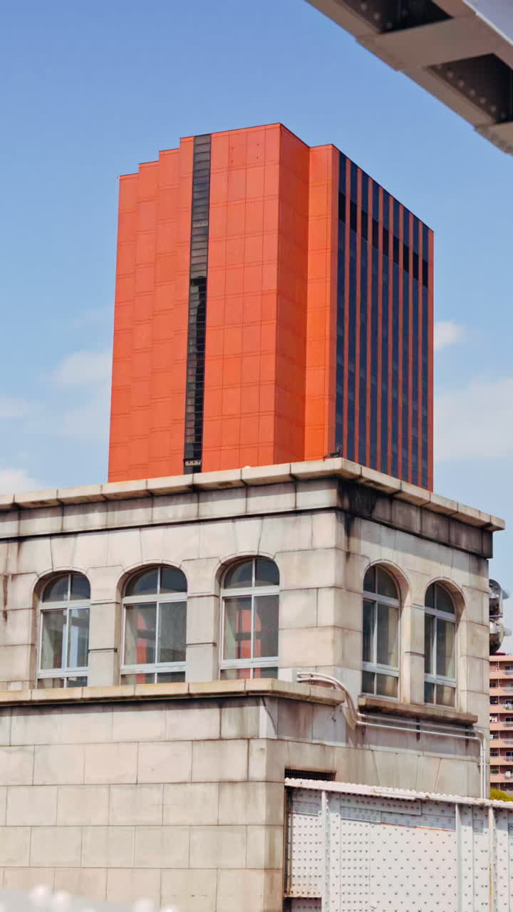 View of buildings in Chuo, Japan from the Kachidoki Bridge in daylight. Vertical