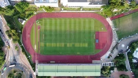 People-during-Early-morning-Jogging-on-a-racetrack-with-long-starched-silhouettes,-Aerial-view