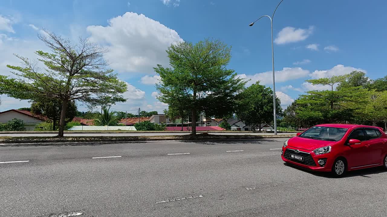 Decorative trees line the road median and roadside edges. They provide shade for both commuters and pedestrians using the area. These trees also function as a natural safety barrier during accidents