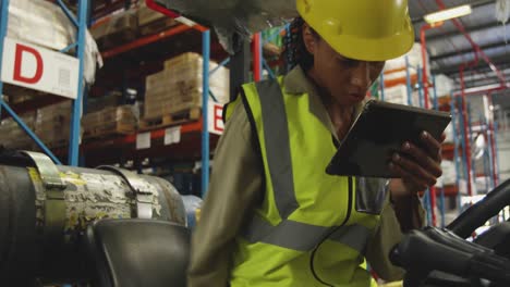 Young-female-worker-driving-forklift-in-a-warehouse