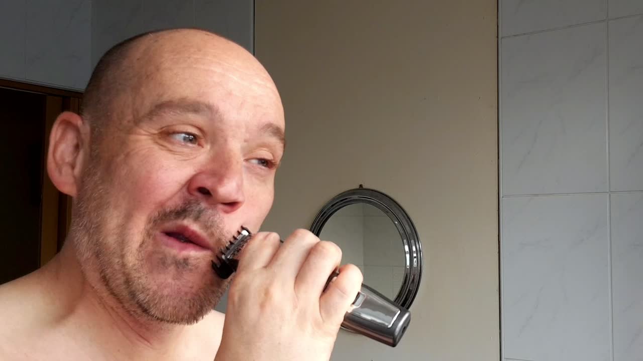 Male shaves with an electric razor