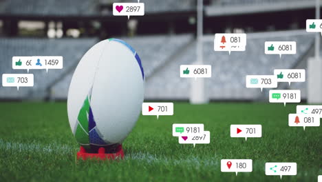 animation of social media icons foating against close up of a rugby ball on a stand in the stadium
