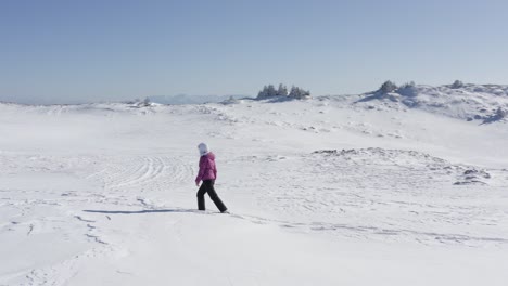 Drone-following-young-woman-in-mountains-walking-alone