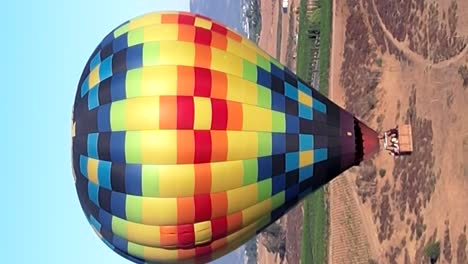 Vista-Aérea-De-Un-Globo-Aerostático-Multicolor-Que-Vuela-Sobre-Temecula