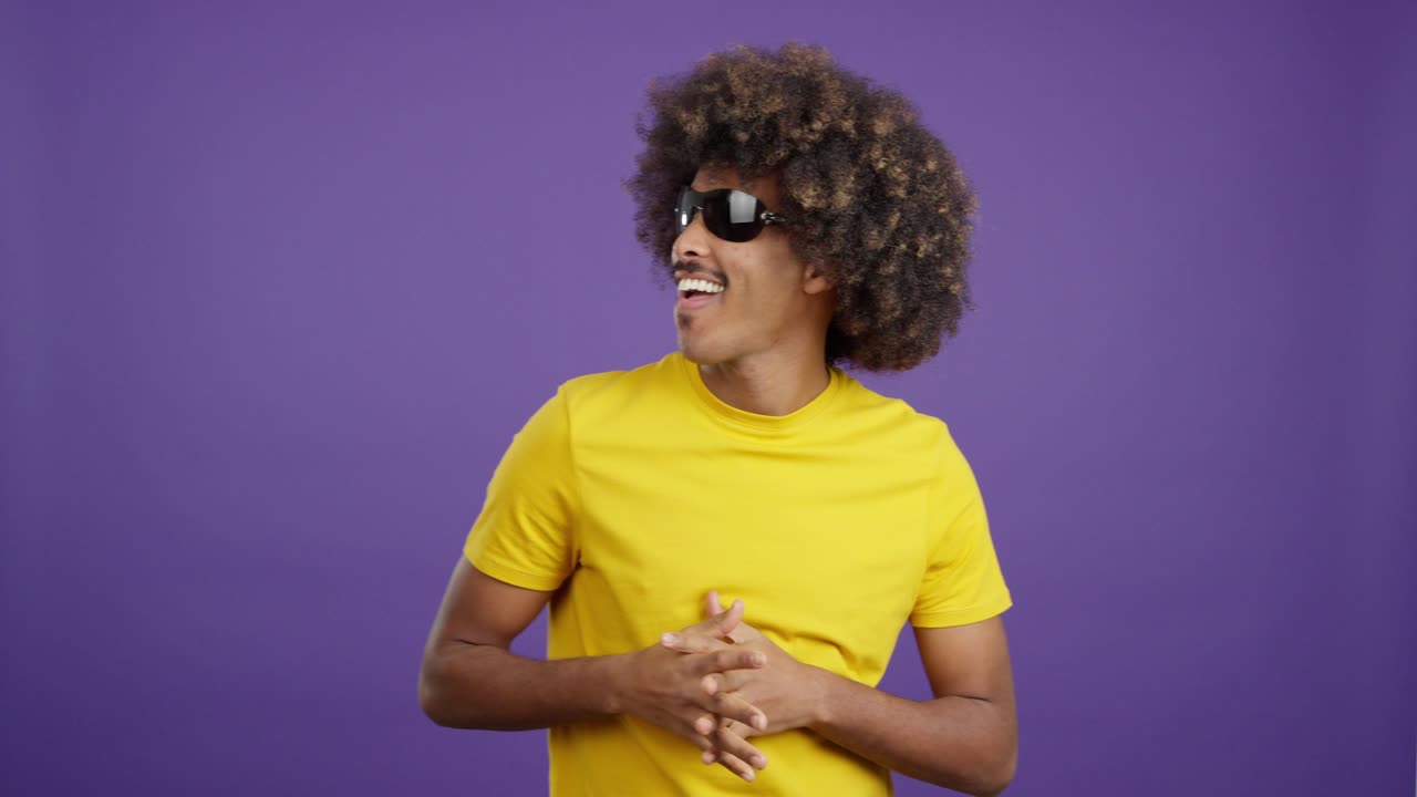 Man with Afro and Sunglasses Posing on Purple Background