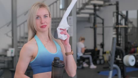 portrait of a young positive blonde woman in a large modern gym holding a kettlebell portrait of a young positive blonde woman in a large modern gym holding a kettlebell healthy lifestyle and exercise concept