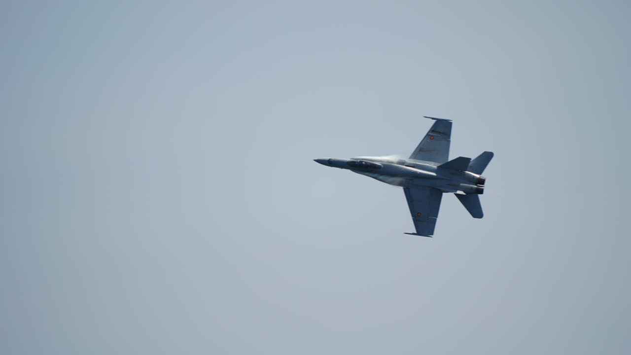 Fighter jet in sky captured with tilted angle during high speed directional turn