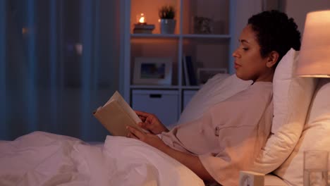 young pretty woman relaxing on bed reading a book in the morning at home.young pretty woman relaxing on bed reading a book in the morning at home. leisure activities and culture concept. vertical video.