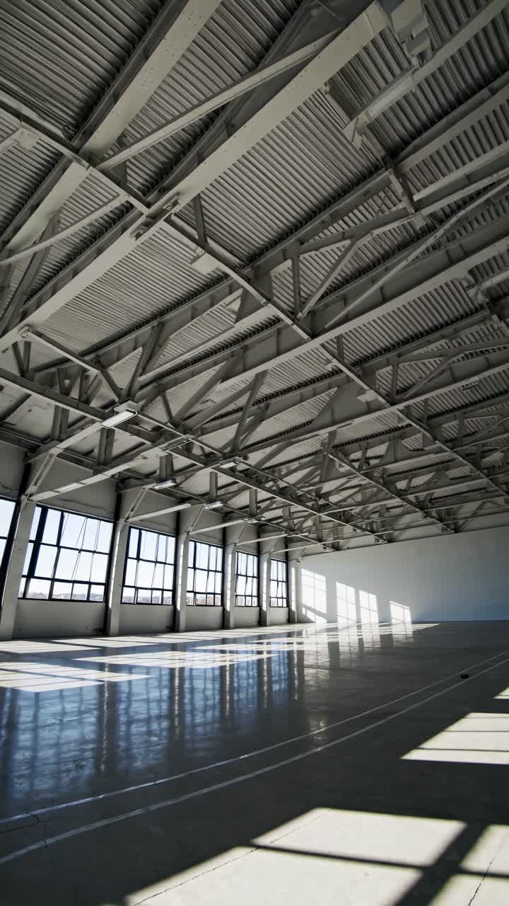 Interno moderno di magazzino vuoto con luce solare e ombre